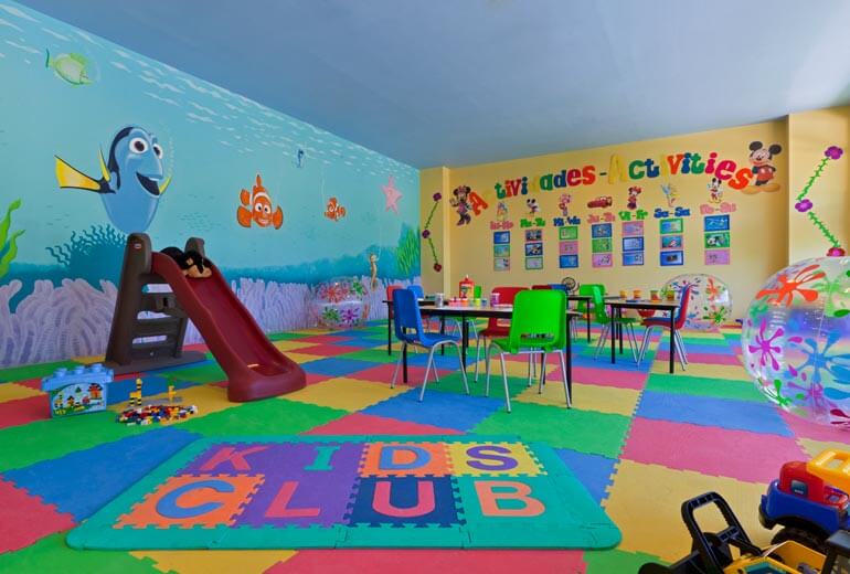Salle de jeux Kids Club avec toboggan, tables colorées et fresques murales marines au Panama