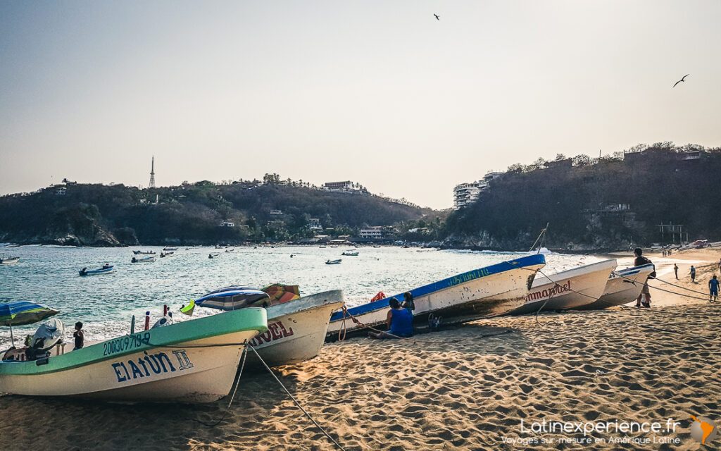 Bateaux de pêche colorés échoués sur une plage de sable, baie côtière au Mexique