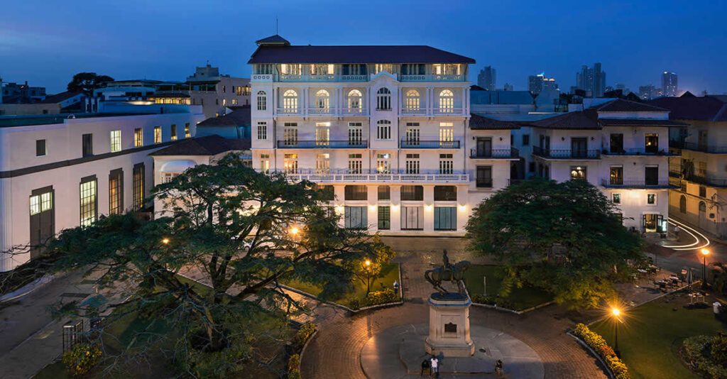 Place historique illuminée du Casco Viejo à Panama City, avec statue équestre et bâtiment colonial