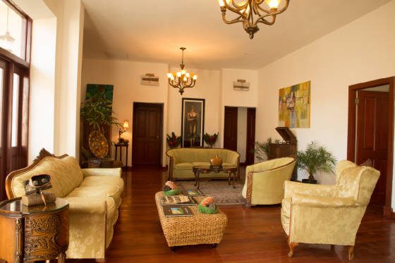 Salon d'hôtel à Panama City avec fauteuils dorés, parquet en bois et lustres suspendus