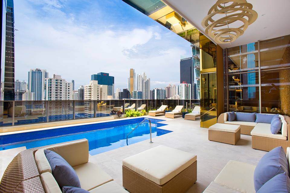 Piscine sur toit-terrasse d'hôtel avec salons extérieurs et vue sur les gratte-ciel de Panama City