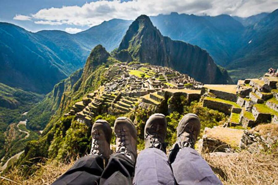 Randonneurs assis face au Machu Picchu, vue panoramique depuis un sommet, Pérou