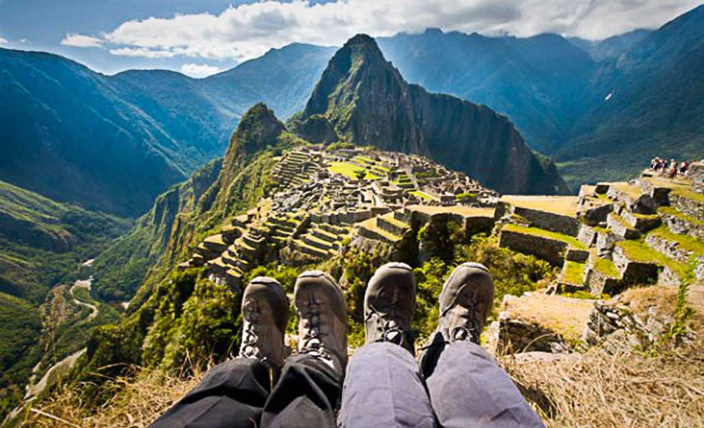 Randonneurs assis face au Machu Picchu, vue panoramique depuis un sommet, Pérou