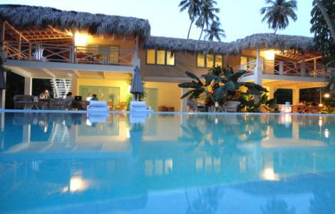 Villa avec toit de chaume et piscine éclairée au crépuscule, Barahona, République Dominicaine