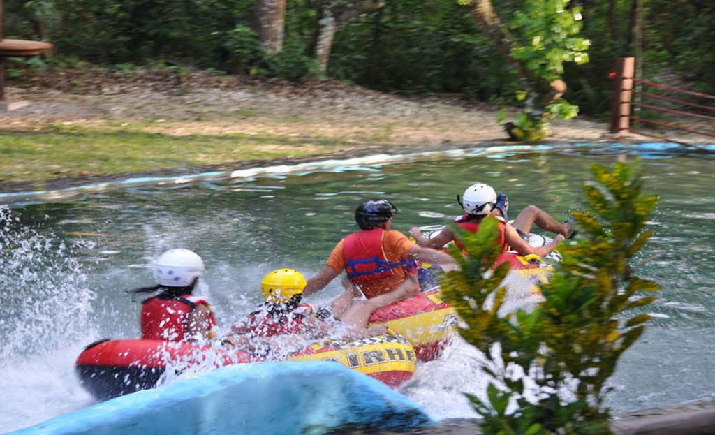 Personnes en canot pneumatique avec casques dévalant un canal d'eau vive, République Dominicaine