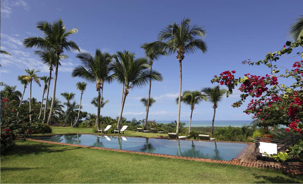 Piscine bordée de palmiers et bougainvillées avec vue sur l'océan à Las Terrenas, République Dominicaine