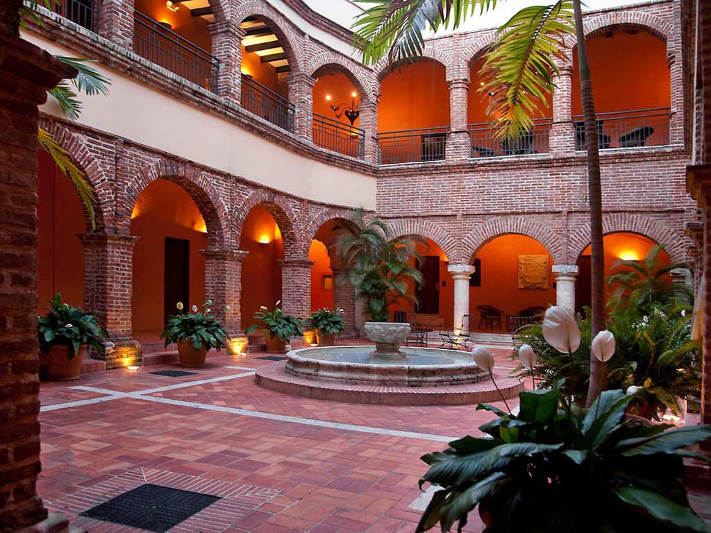Patio colonial en briques avec fontaine et plantes tropicales, Saint-Domingue, République Dominicaine
