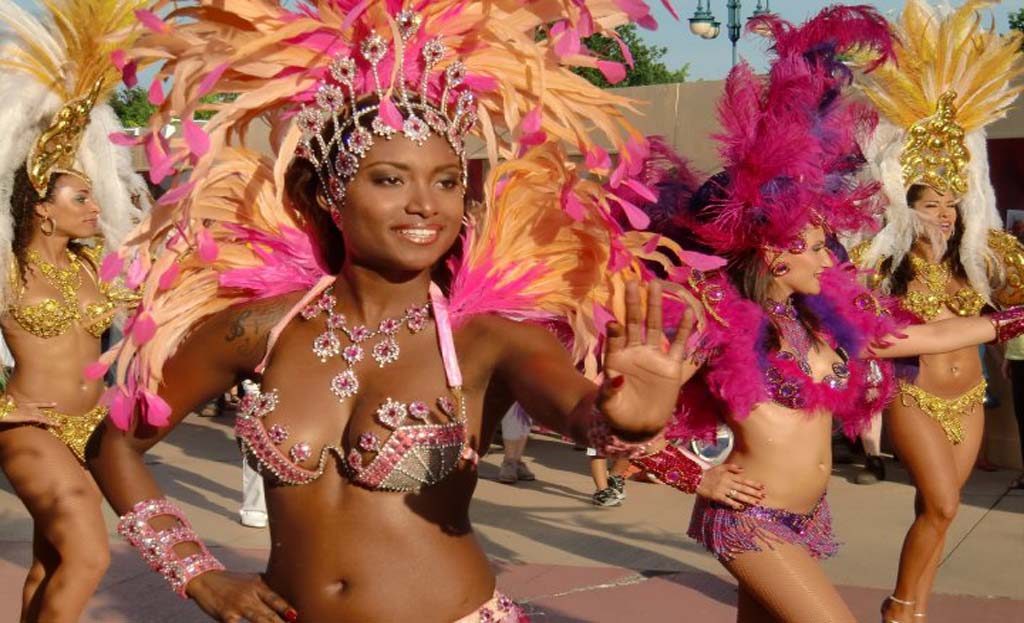 Danseuses de carnaval en costumes de plumes colorés défilant dans une rue, Venezuela