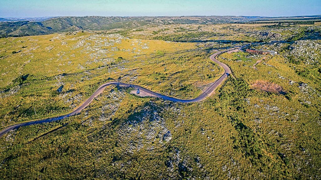 Vue aérienne d'une route sinueuse traversant les collines rocheuses de Minas, Uruguay