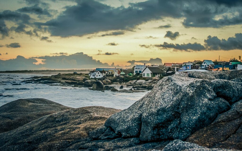 Côte rocheuse et maisons du village de Punta Del Diablo au coucher du soleil, Uruguay