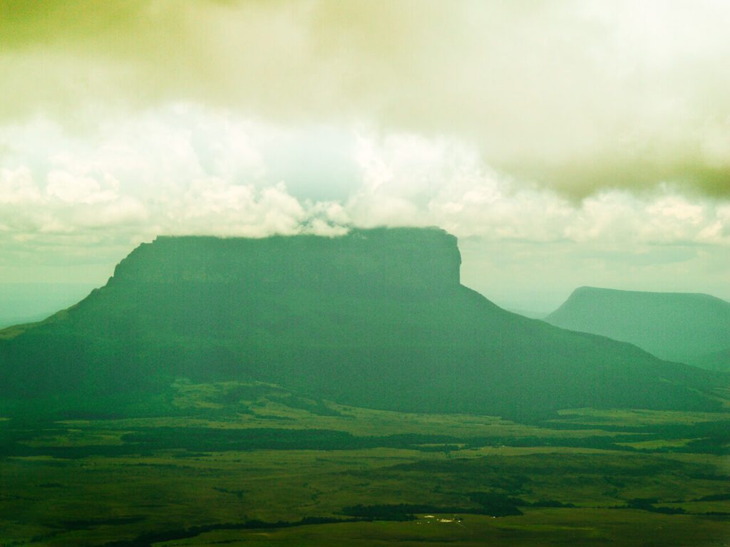 Tepuy à sommet plat sous les nuages surplombant la savane vénézuélienne, sans cascade visible