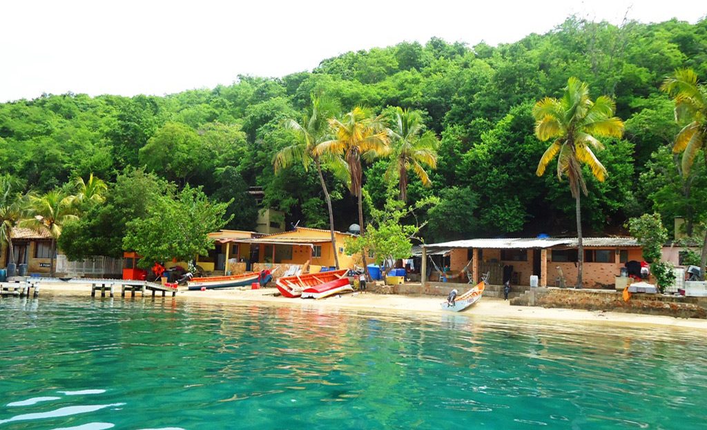 Village de pêcheurs avec bateaux colorés et cabanes en bord de plage, parc national de Mochima Venezuela