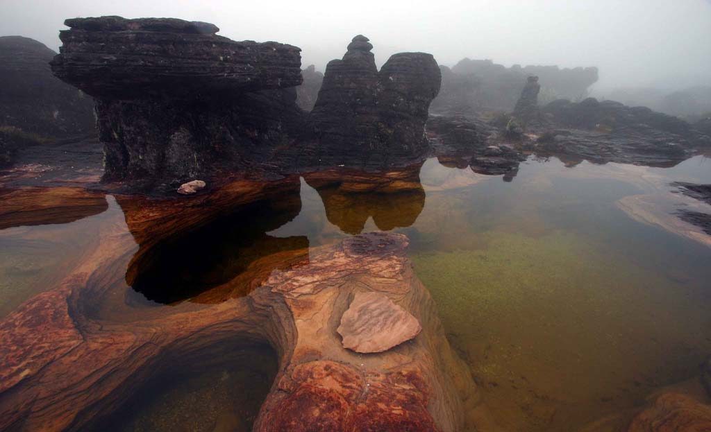 Formations rocheuses sombres et bassin d'eau au sommet du Roraima, Venezuela