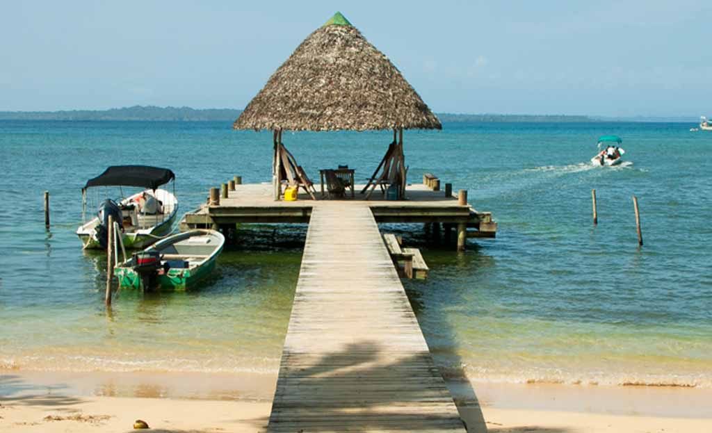 Ponton en bois avec kiosque de chaume et bateaux amarrés à Bocas del Toro, Panama