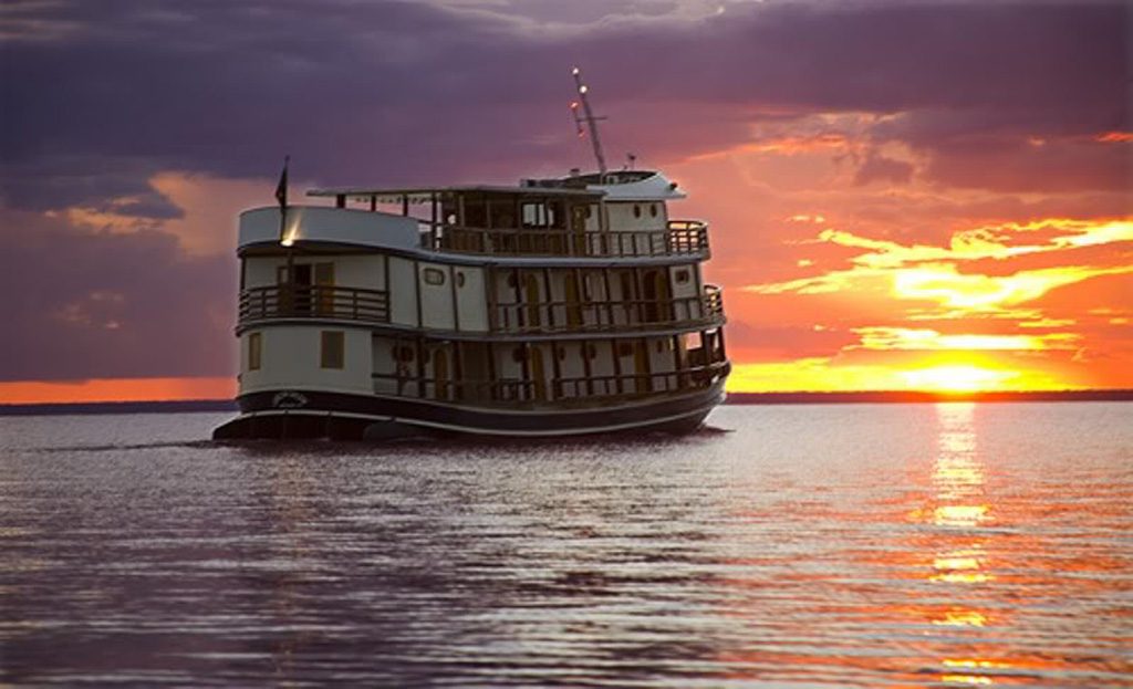 Bateau de croisière à trois ponts naviguant au coucher du soleil, Amazonie brésilienne