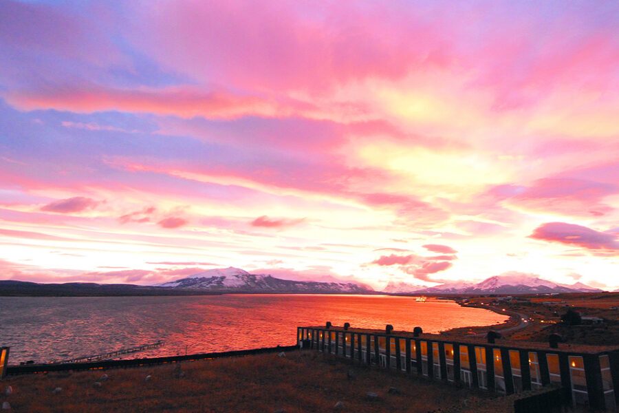 Coucher de soleil rose et orangé sur le fjord et les montagnes près du lodge Remota, Patagonie chilienne
