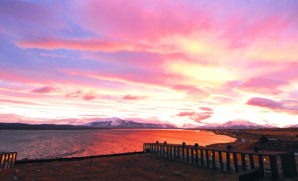 Coucher de soleil rose et orangé sur le fjord et les montagnes près du lodge Remota, Patagonie chilienne