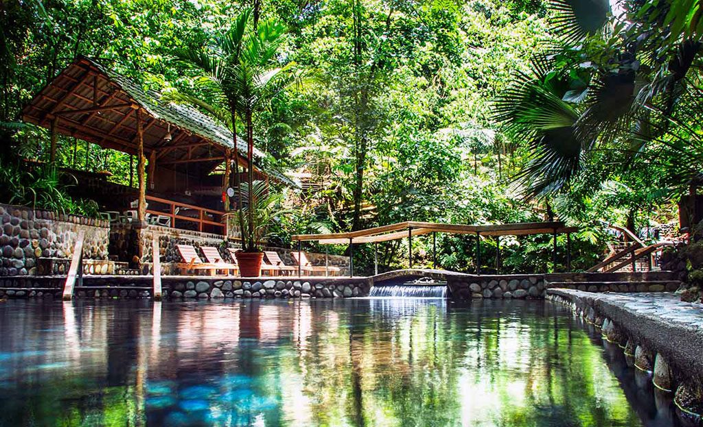 Piscine d'eaux thermales entourée de forêt tropicale avec pavillon en bois, Costa Rica
