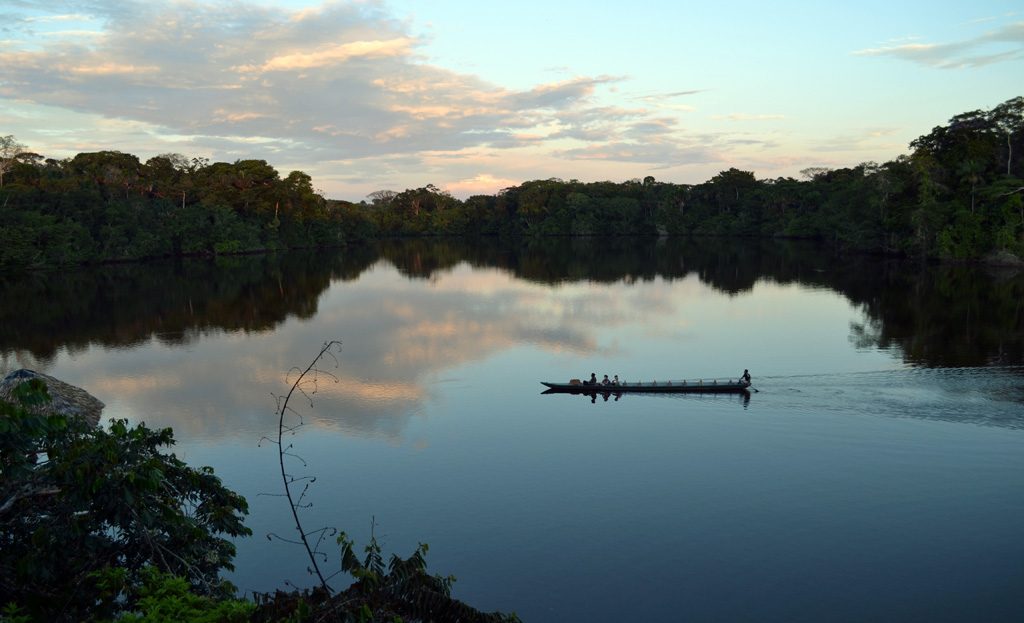 Canoë glissant sur le lac Garzacocha entouré de forêt amazonienne équatorienne dense