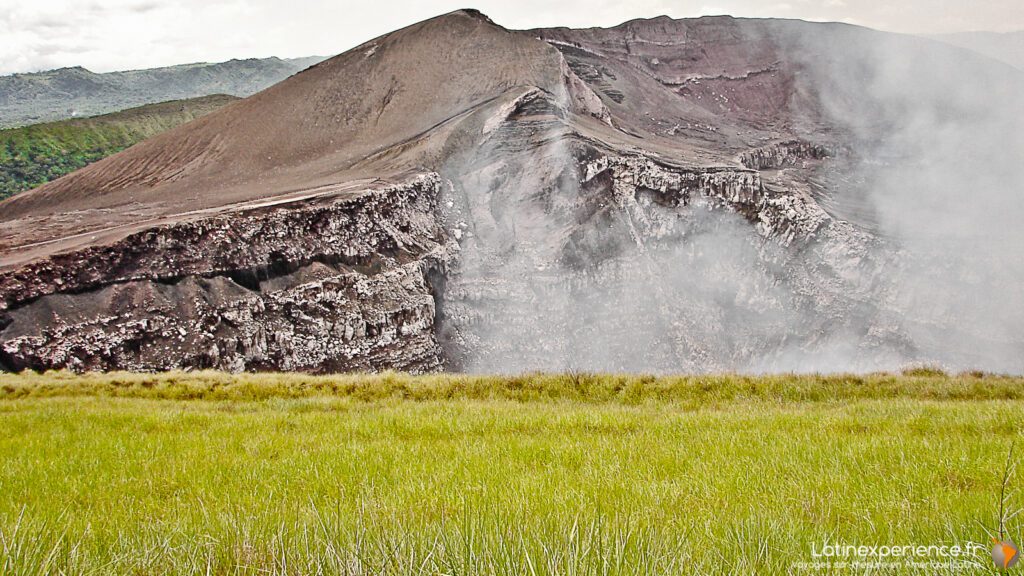 Cratère du volcan Masaya avec fumerolles, vu depuis une prairie herbeuse, Nicaragua