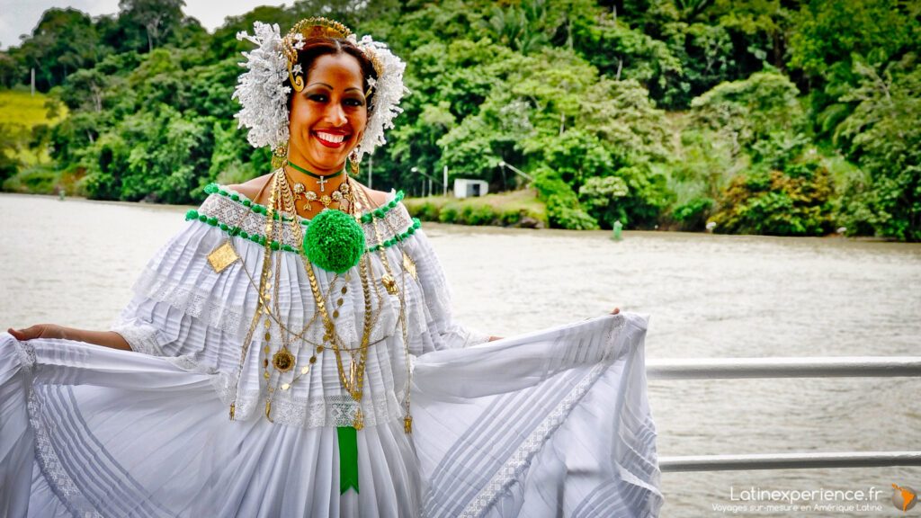 Femme portant une pollera traditionnelle blanche et or près d'un fleuve au Panama