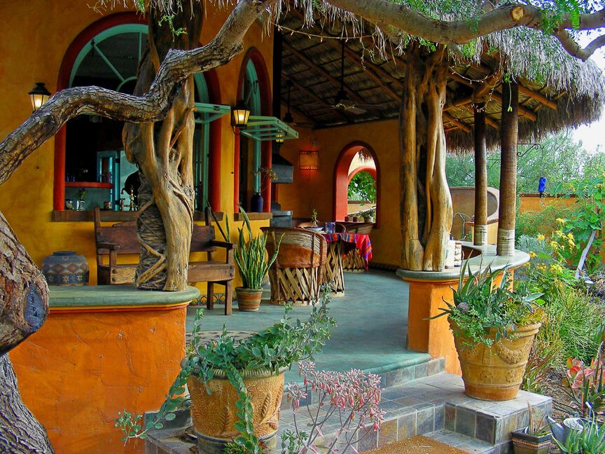 Terrasse mexicaine ombragée avec murs ocre, plantes en pots et toit de palapa à Cabo Pulmo