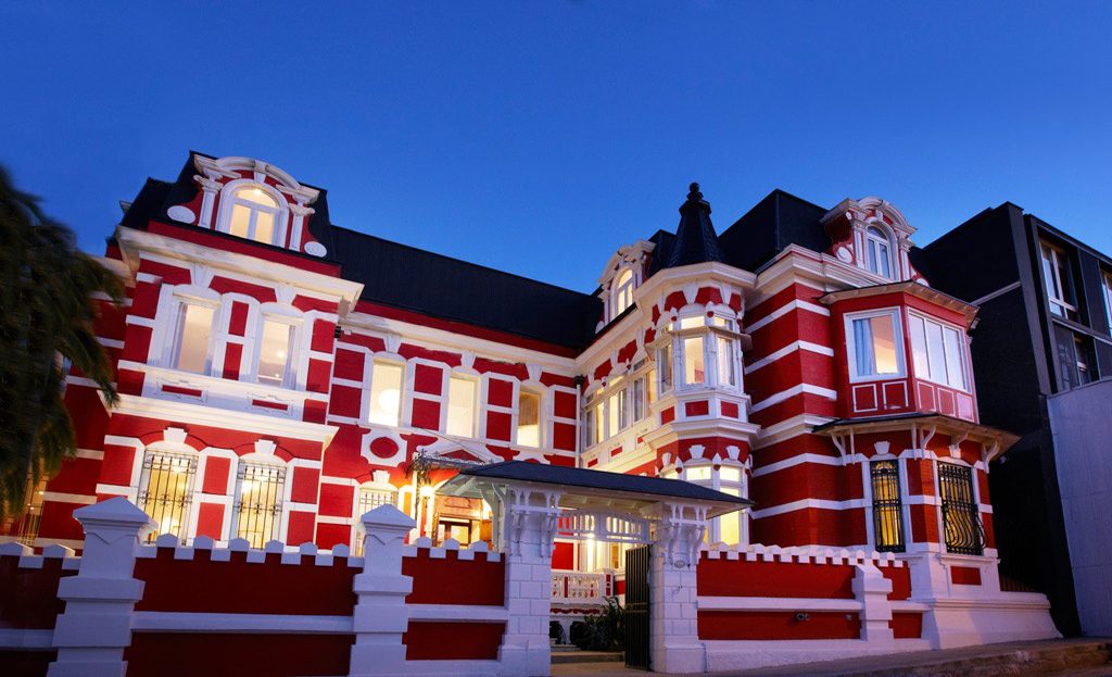 Bâtiment historique rouge et blanc illuminé au crépuscule à Valparaiso, Chili
