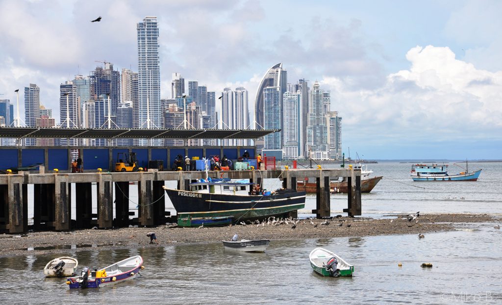 Bateaux de pêche amarrés près d'un quai avec les gratte-ciel de Panama City en arrière-plan