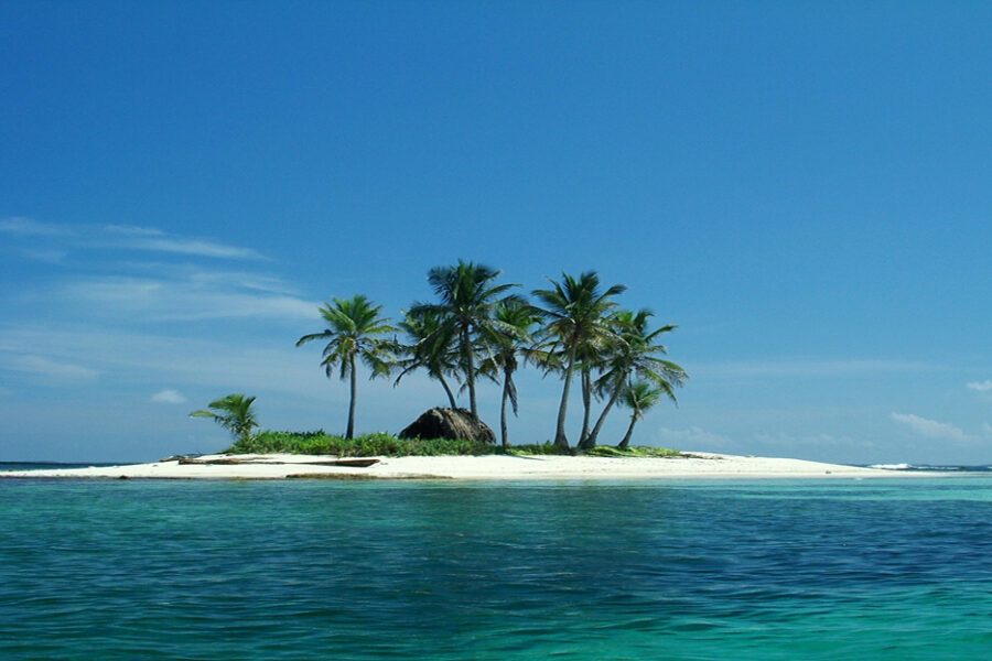 Petite île San Blas avec palmiers, cabane en paille et lagon turquoise, Panama