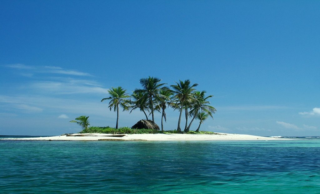 Petite île San Blas avec palmiers, cabane en paille et lagon turquoise, Panama
