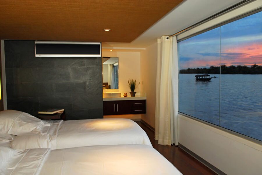 Cabine de croisière sur l'Amazone avec lits jumeaux et vue fenêtre au coucher du soleil, Pérou