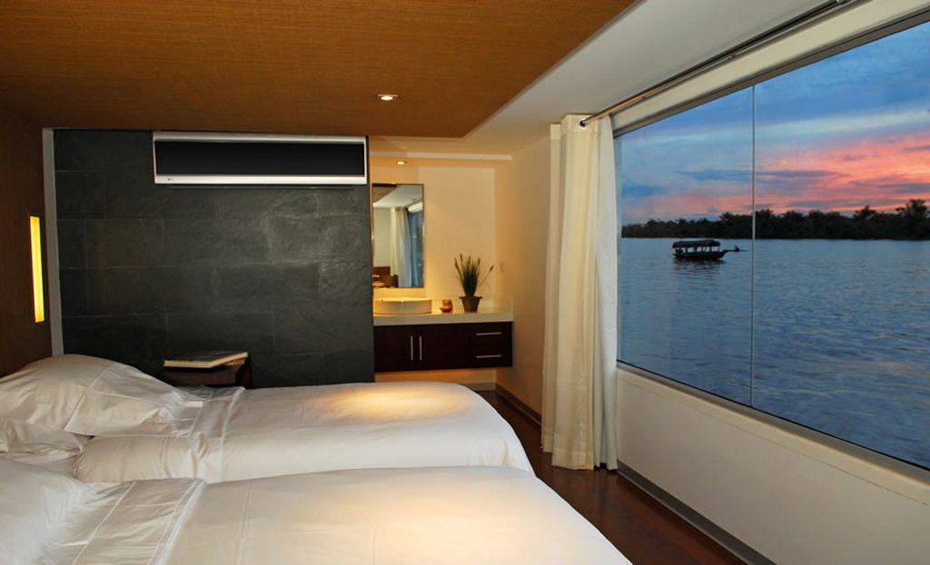 Cabine de croisière sur l'Amazone avec lits jumeaux et vue fenêtre au coucher du soleil, Pérou