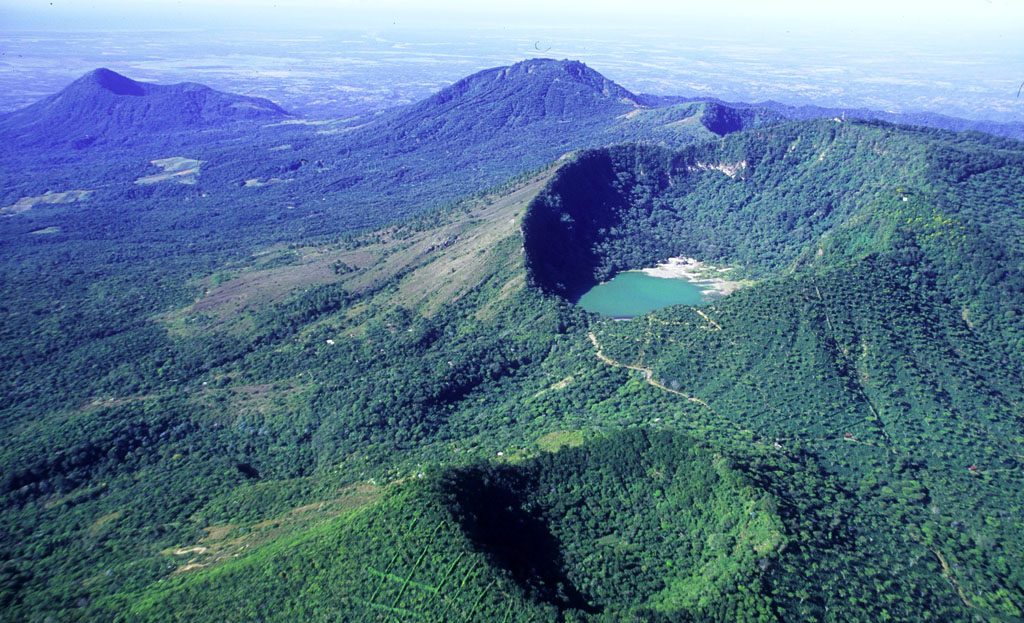 Vue aérienne d'un cratère volcanique boisé avec lac turquoise, chaîne des volcans du Salvador