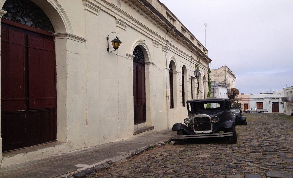 Voiture ancienne noire garée sur une rue pavée devant une façade coloniale à Colonia del Sacramento, Uruguay