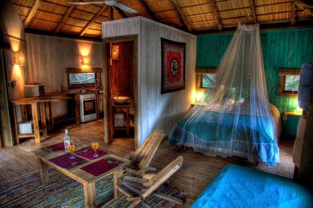 Chambre rustique avec lit à moustiquaire, cuisine équipée et coin repas, Barrancas Eco Lodge, Uruguay