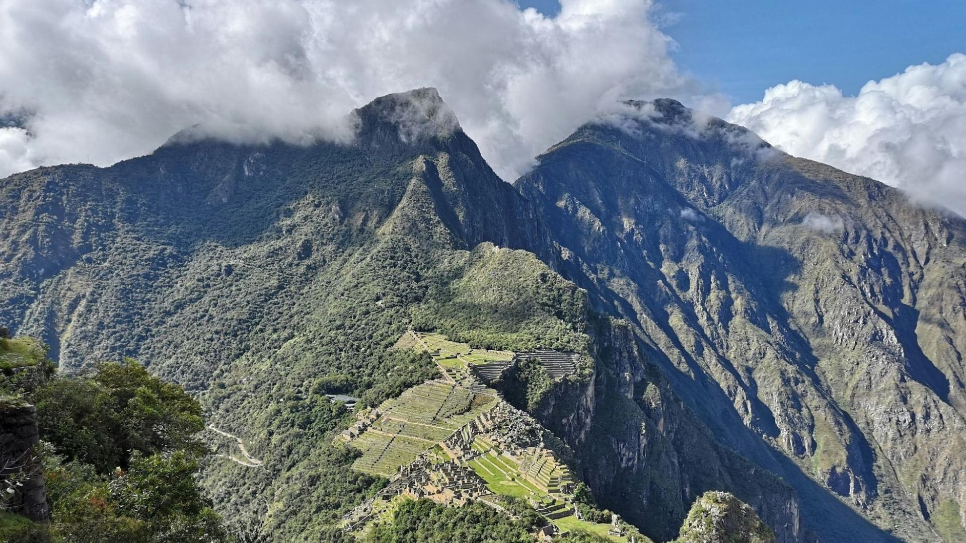 Vue aérienne du site inca du Machu Picchu entouré de montagnes escarpées et de nuages